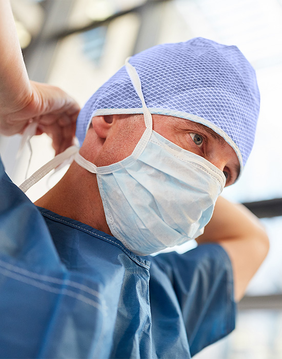 Surgeon putting on mask